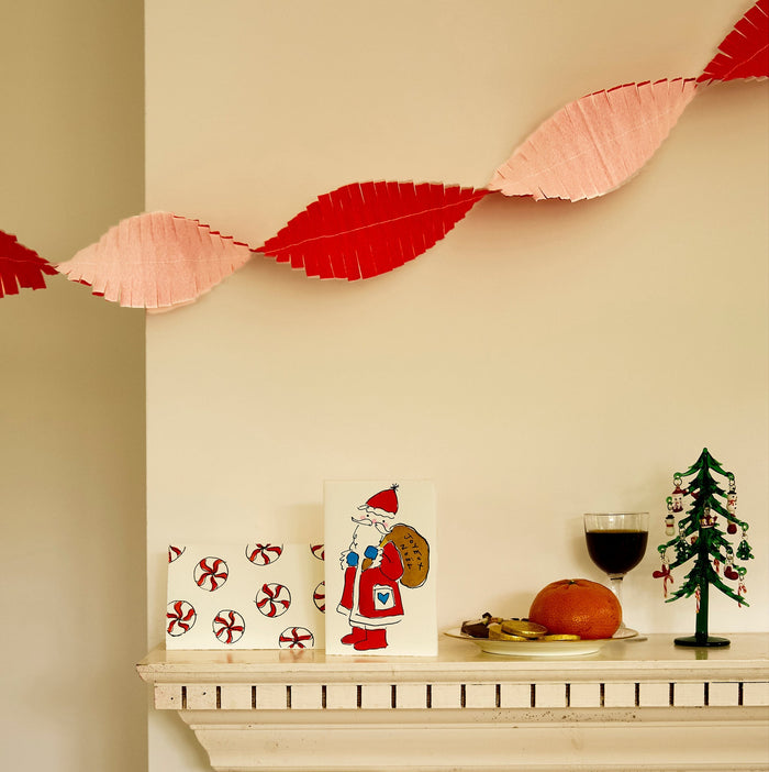 Two Christmas cards by Scribble & Daub on a mantelpiece, Santa Claus and Christmas Candies